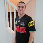 A photo of a smiling man wearing a penrith panthers jersey
